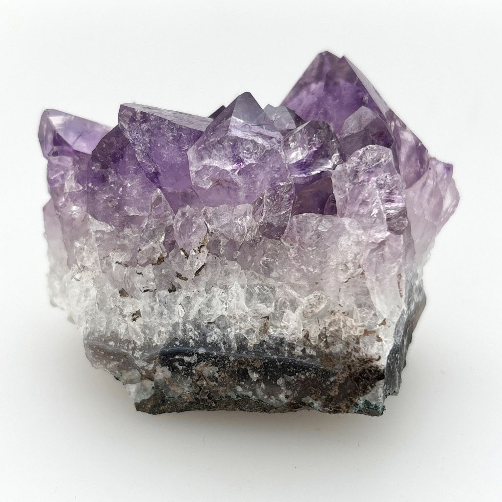 Natural Amethyst crystal cluster with deep purple crystal points growing on a natural quartz matrix, polished by nature and ideal for display or meditation.