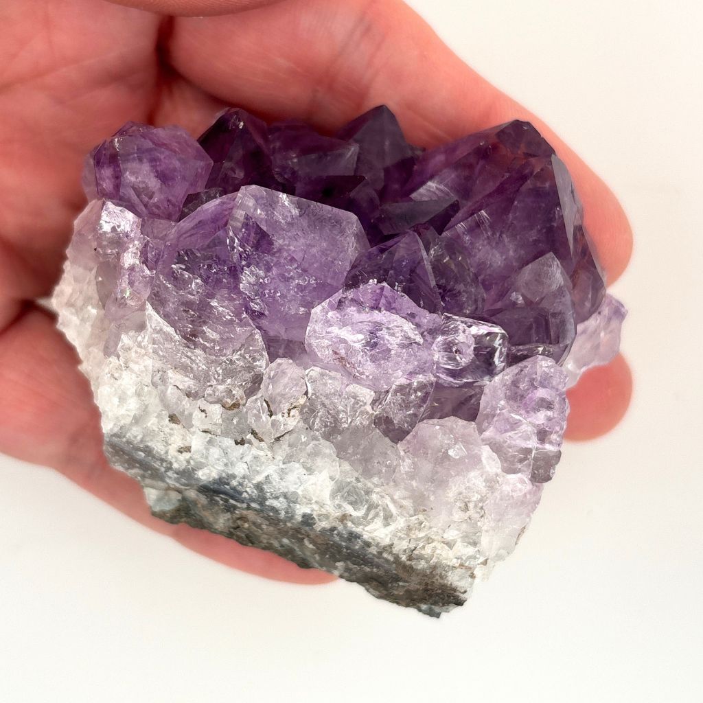 Natural Amethyst crystal cluster with deep purple crystal points growing on a natural quartz matrix, polished by nature and ideal for display or meditation.
