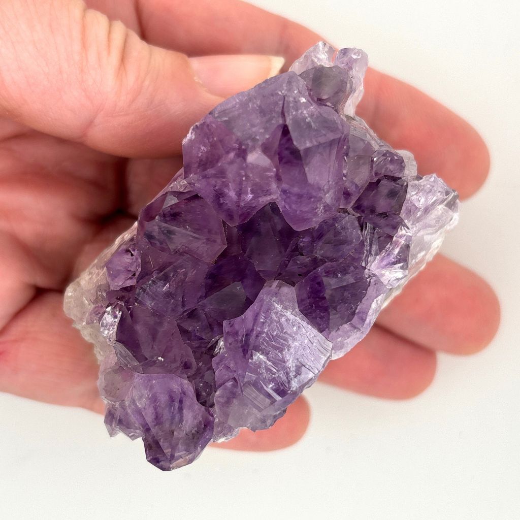 Natural Amethyst crystal cluster with deep purple crystal points growing on a natural quartz matrix, polished by nature and ideal for display or meditation.