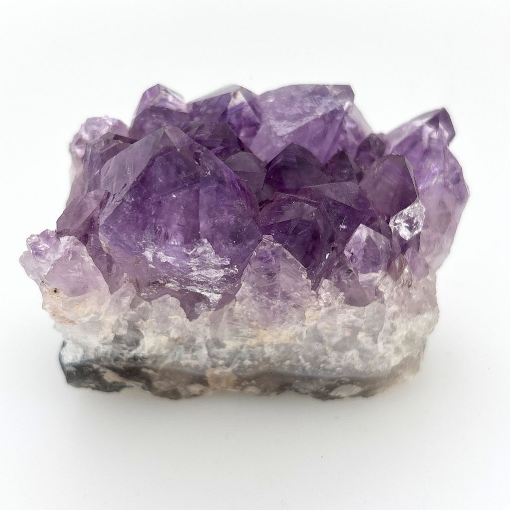 Natural Amethyst crystal cluster with deep purple crystal points growing on a natural quartz matrix, polished by nature and ideal for display or meditation.