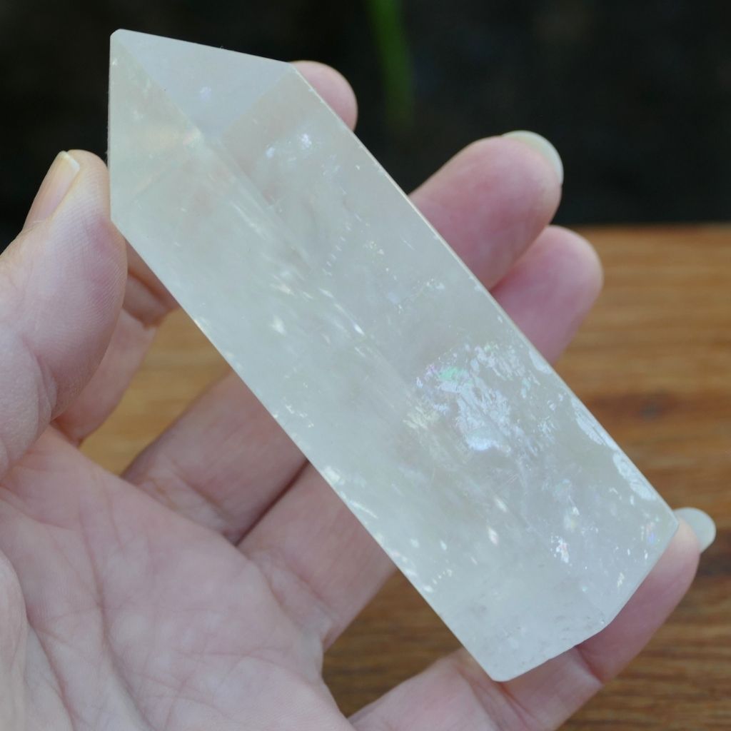 Polished Calcite crystal point tower with natural rainbow inclusions and translucent finish