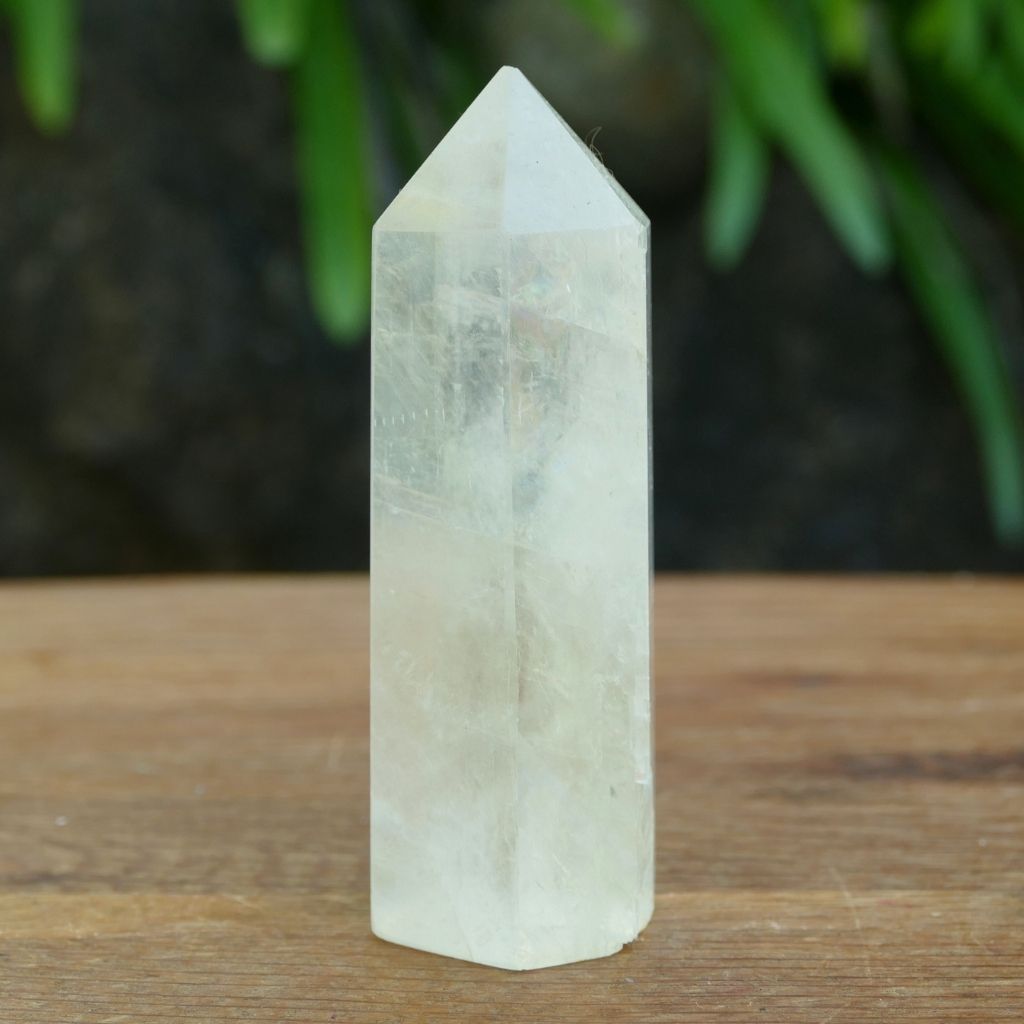 Polished Calcite crystal point tower with natural rainbow inclusions and translucent finish