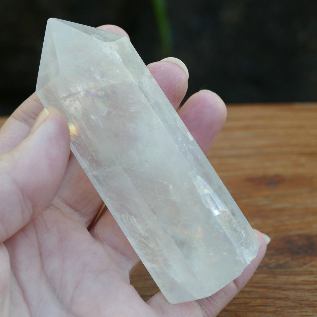 Polished Calcite crystal point tower with natural rainbow inclusions and translucent finish