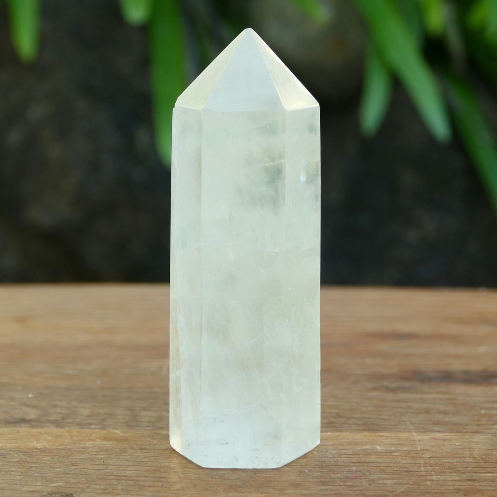 Polished Calcite crystal point tower with natural rainbow inclusions and translucent finish