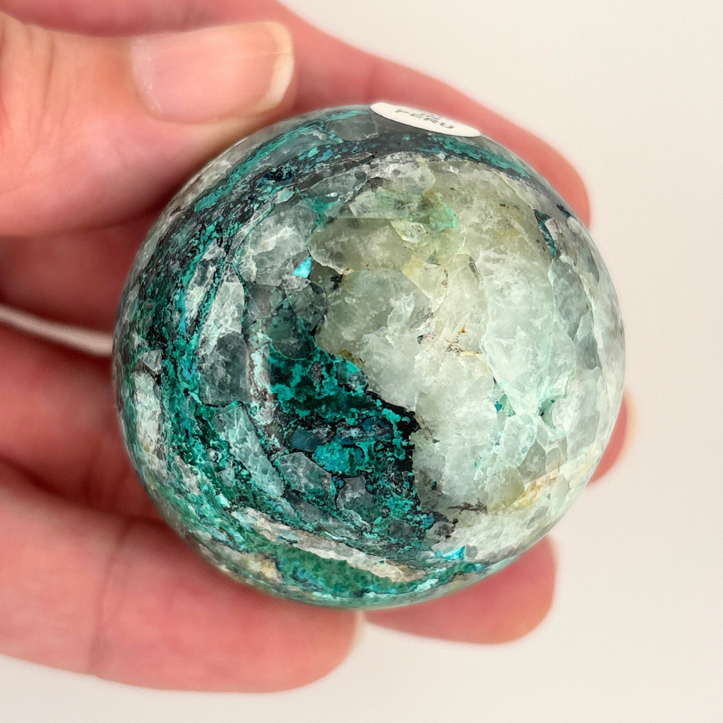 Chrysocolla in quartz crystal sphere from Peru