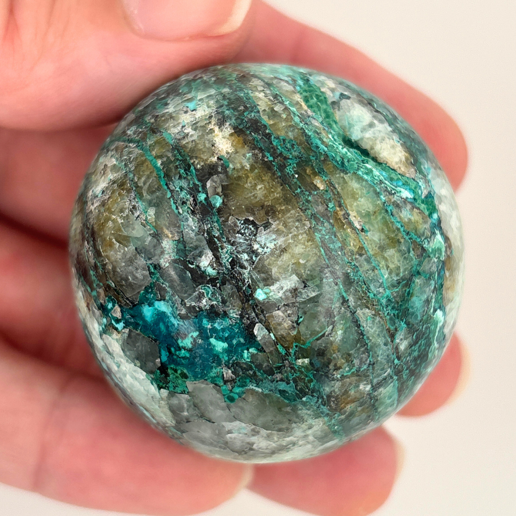 Chrysocolla in quartz crystal sphere from Peru