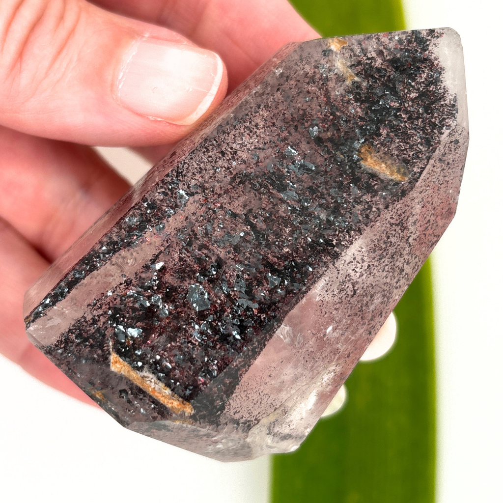 clear quartz point with dark mineral inclusions