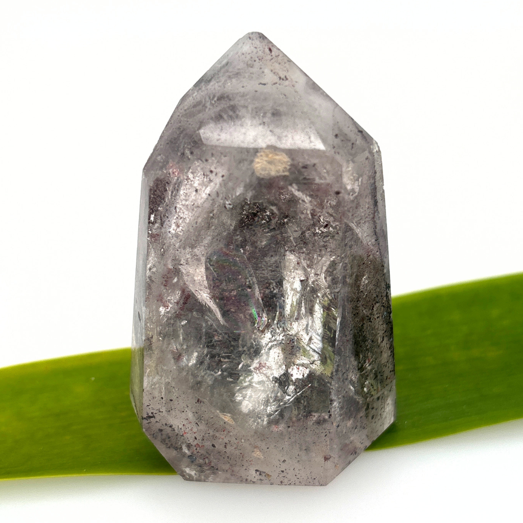 clear quartz point with dark mineral inclusions