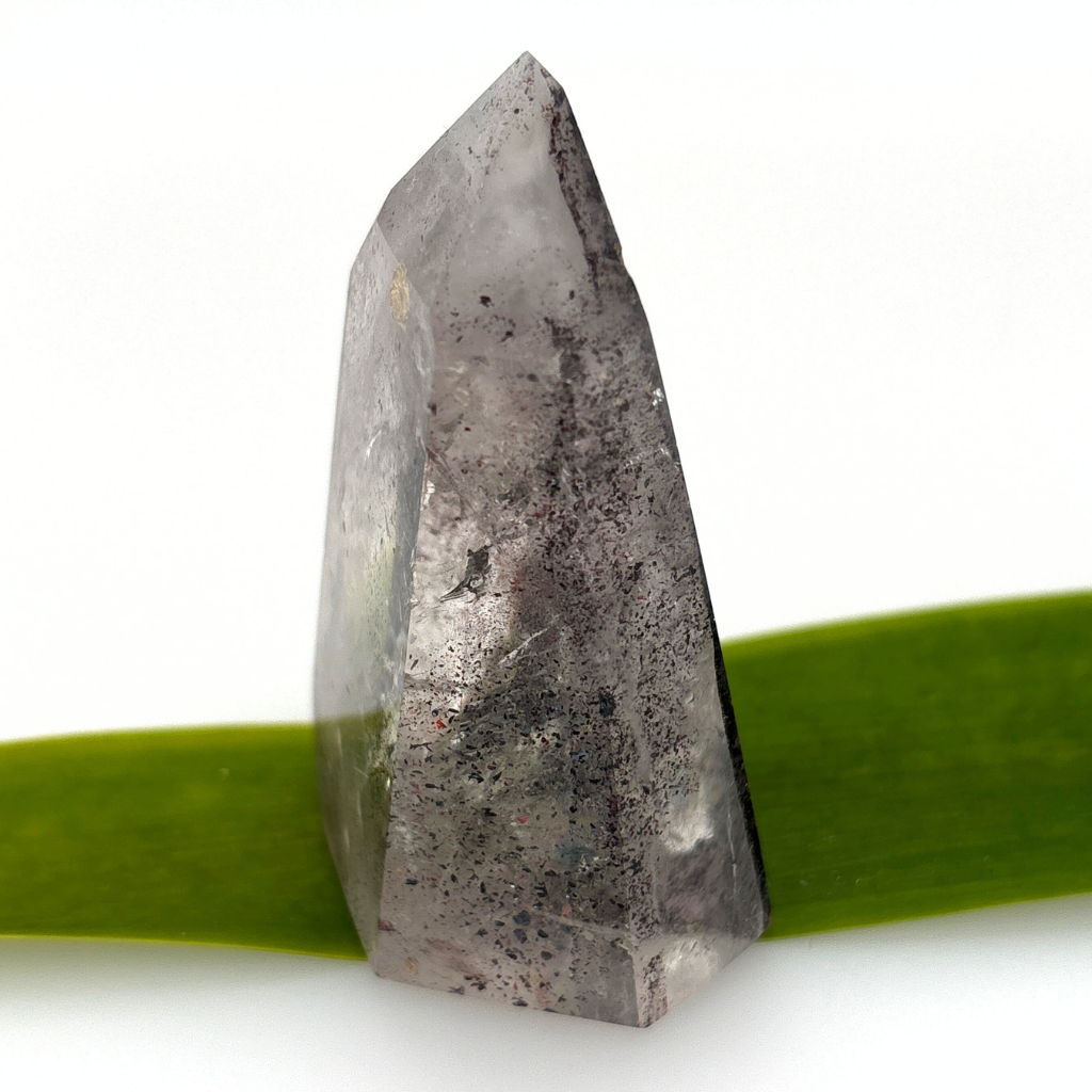 clear quartz point with dark mineral inclusions