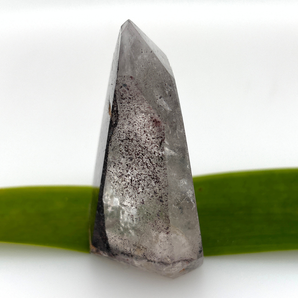 clear quartz point with dark mineral inclusions