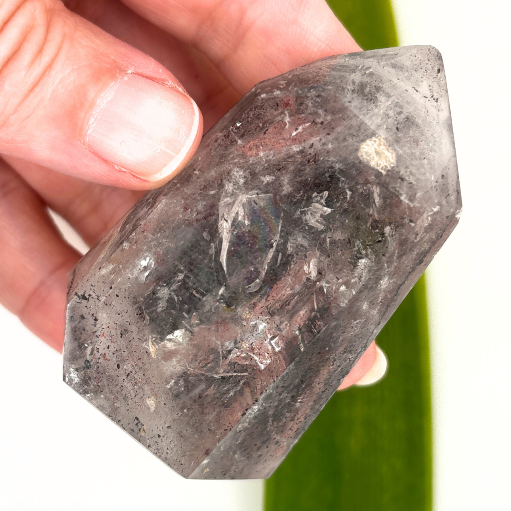 clear quartz point with dark mineral inclusions