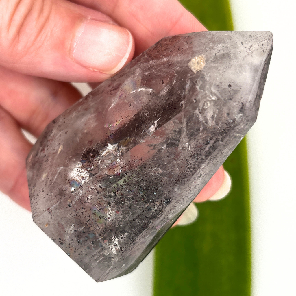 clear quartz point with dark mineral inclusions