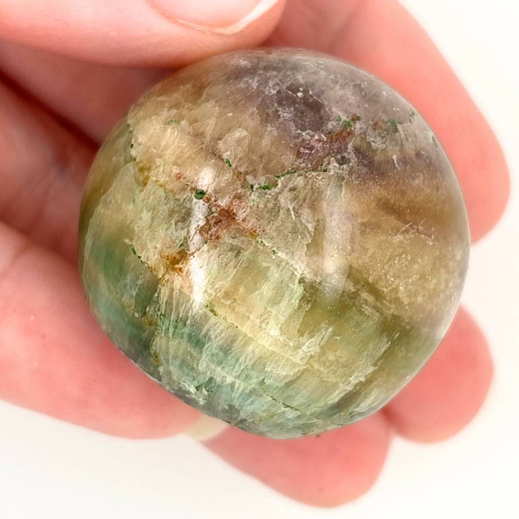 Polished Fluorite crystal sphere with green, gold and lavender natural banding and flat cut base for display